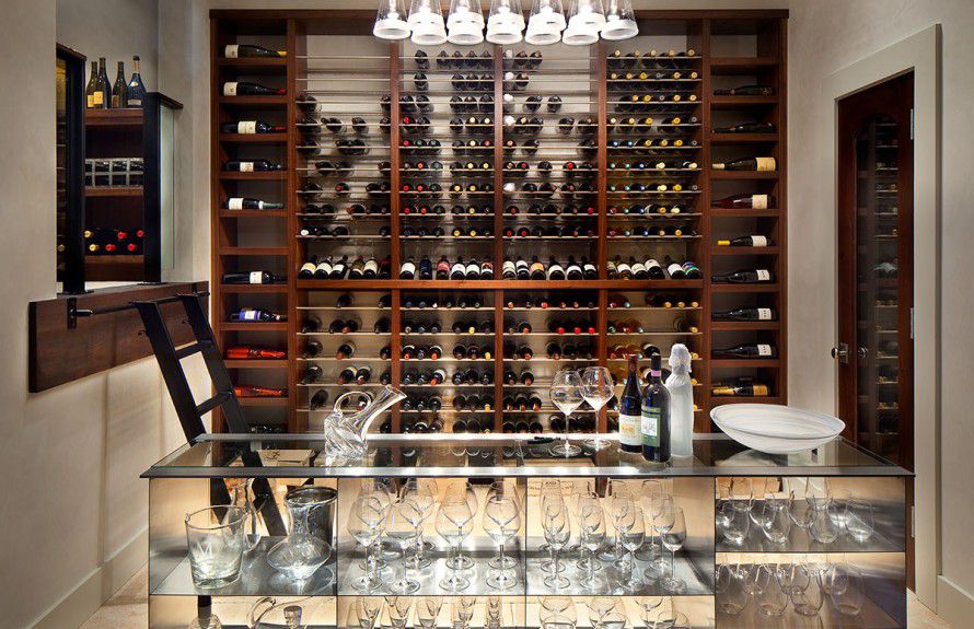 custom-wine-rooms - A modern wine room with custom storefront window, custom wine rack, stainless steel console, and metal and wood library ladder designed by Runa Novak of In Your Space Interior Design - InYourSpaceHome.com and RunaNovak.com